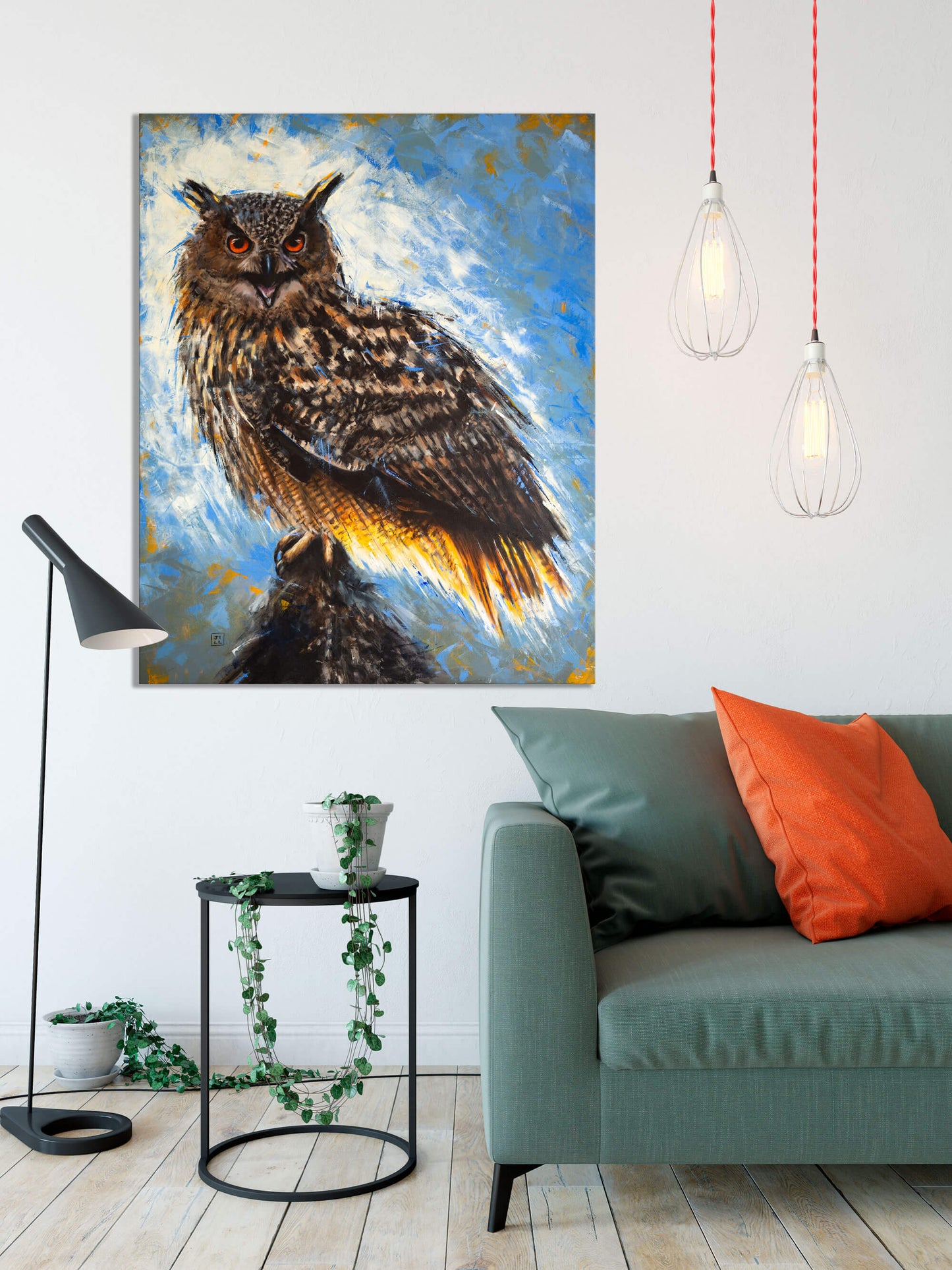 Eurasian eagle owl original oil painting by bird artist Jill Dimond, displayed on a white wall in a room with lamps, a plant on a table and a sofa with cushions