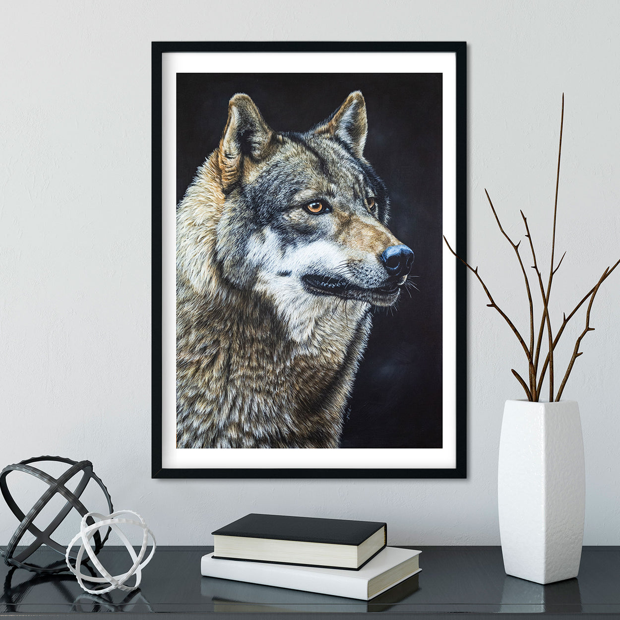 Image of a wolf portrait painting in a black frame on a white wall